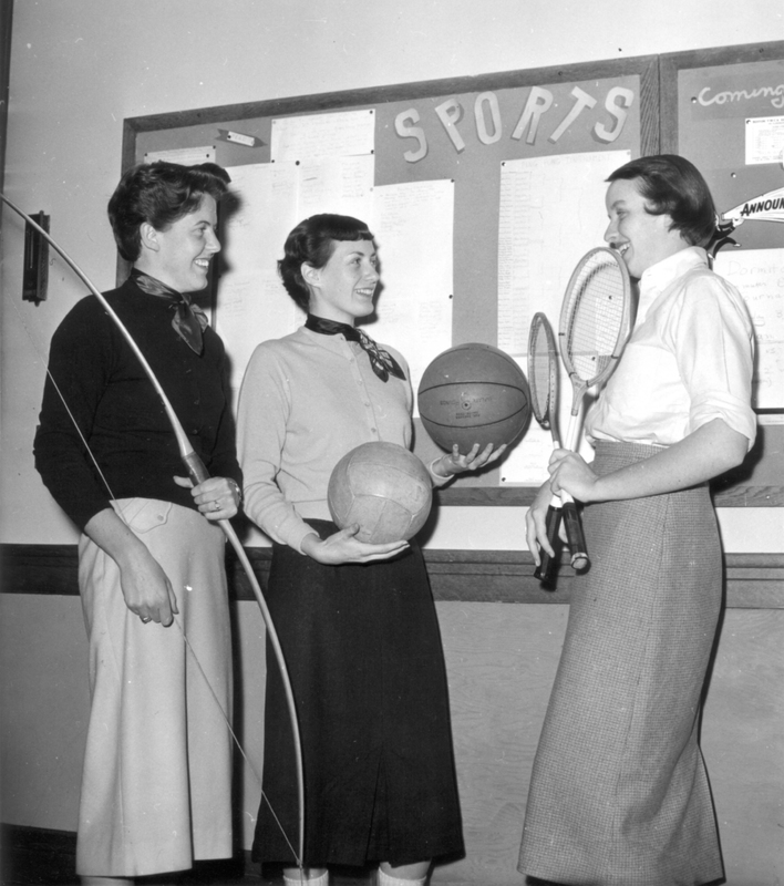 Students holding athletic equipment (1956)